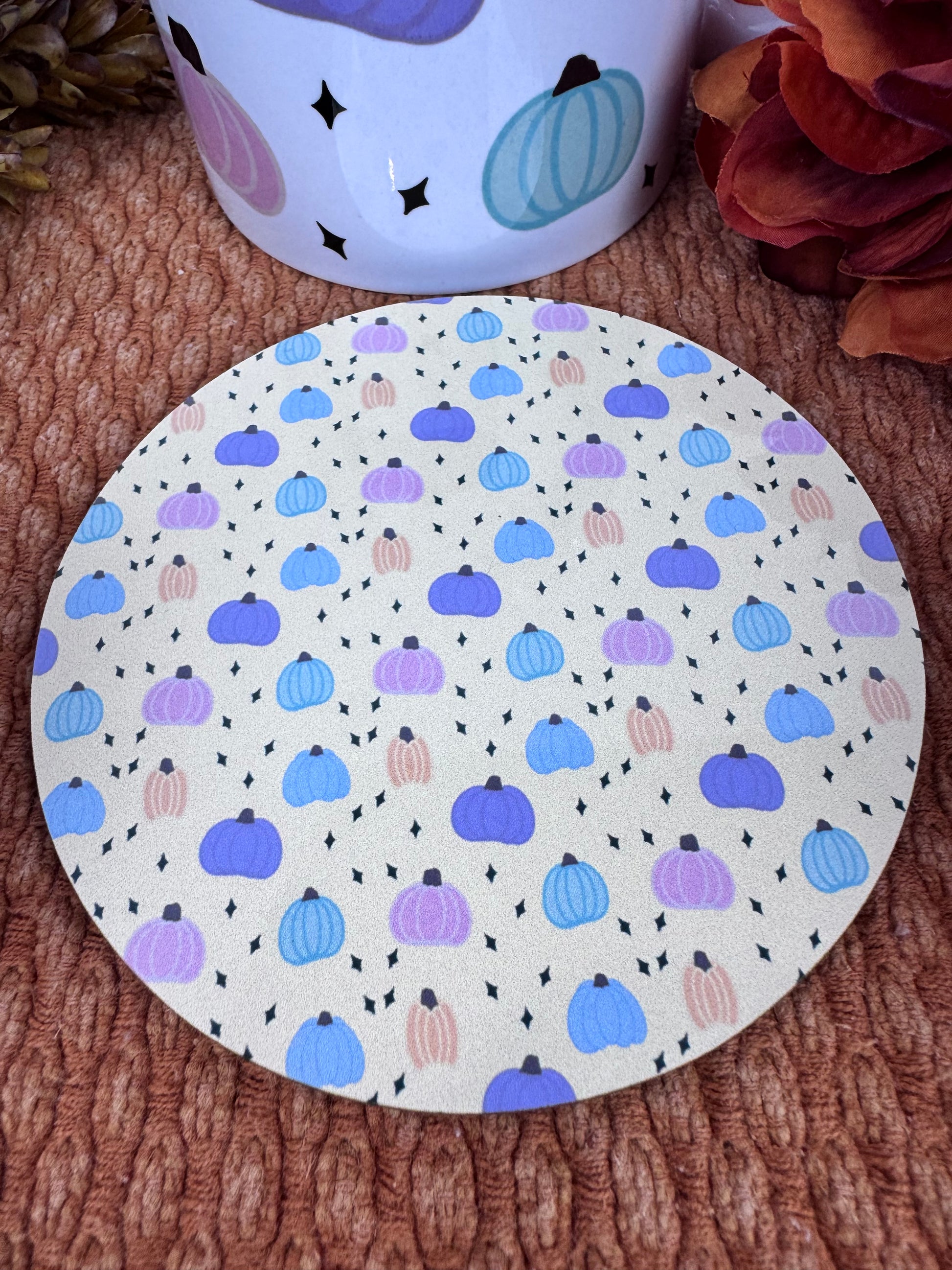 Round MDF coaster with hand drawn pastel pumpkin design on yellow beige background