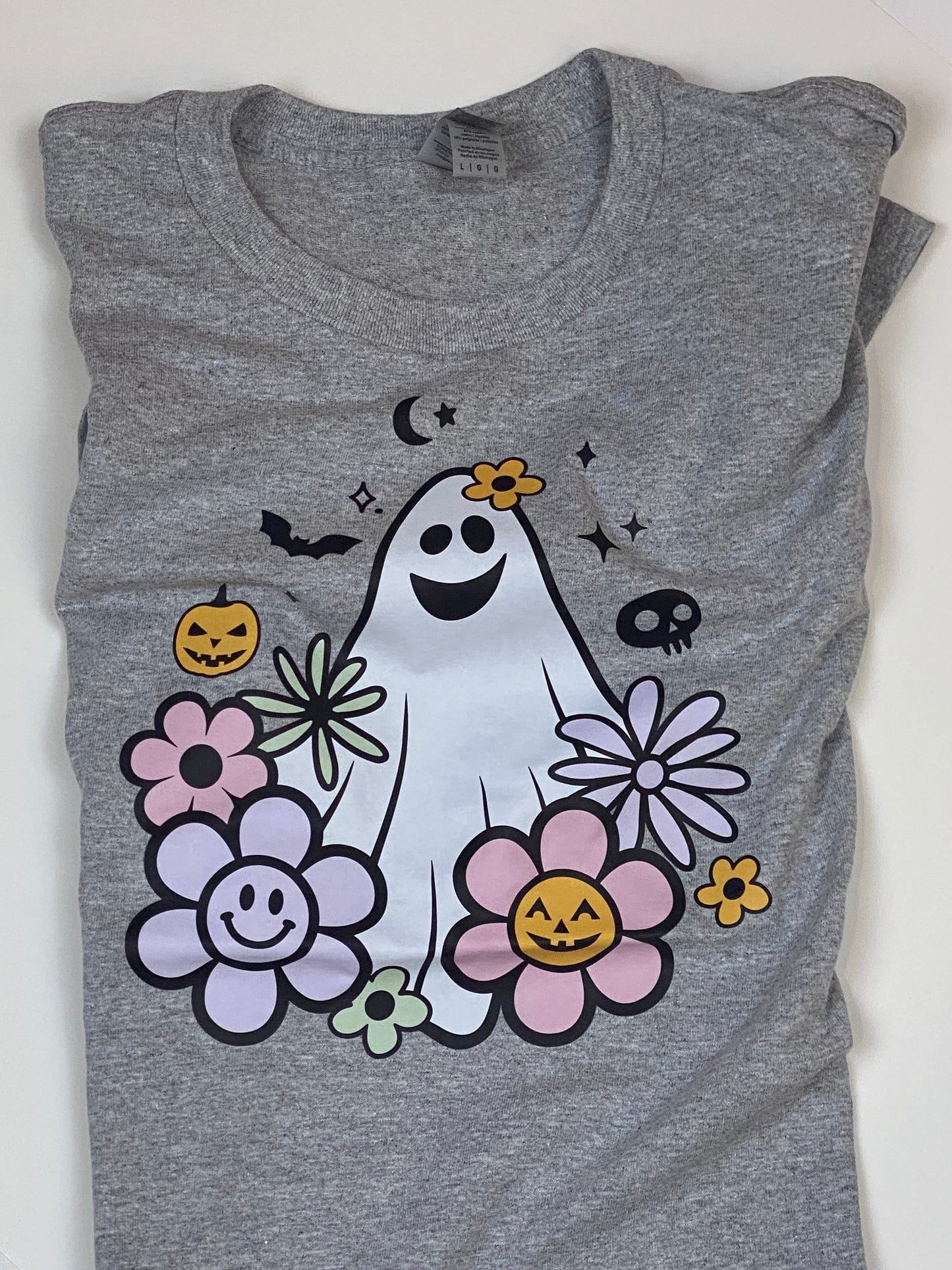 Retro 70’s Style Halloween Graphic Tee with Goofy Ghost, Flowers, Pumpkins, Bats, and Skulls. Fall Autumn Seasonal Apparel